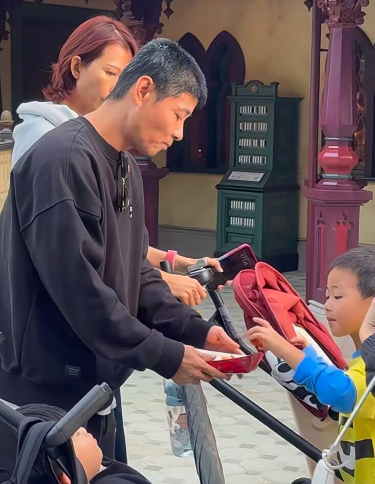 蔡少芬一家迪士尼游，张晋50岁满头白发，拿小吃逗儿子乐